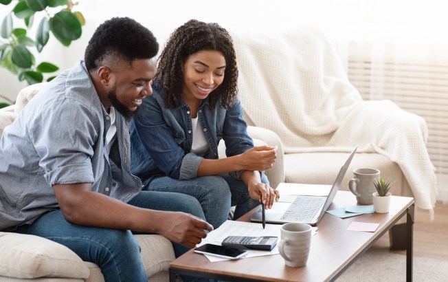 Couple reviewing a winter budget at home on a laptop.