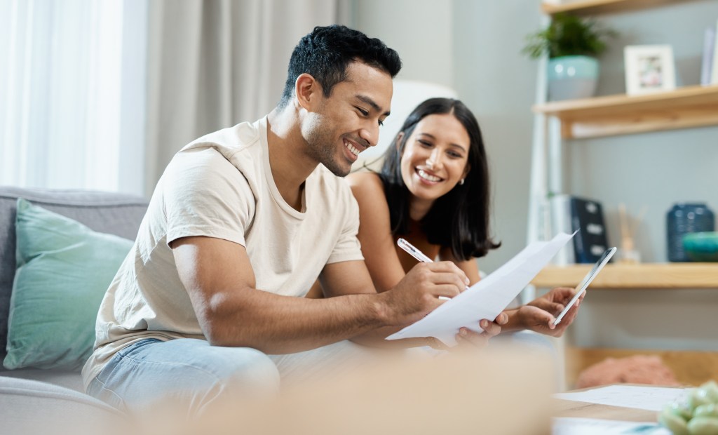 A couple reviewing their first-time homebuyer budget and calculating upfront costs for their down payment and closing fees.
