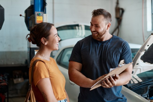 Driver reviewing a car repair estimate while planning a monthly budget